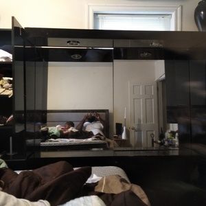 Black wooden dresser with mirror and ten storage b